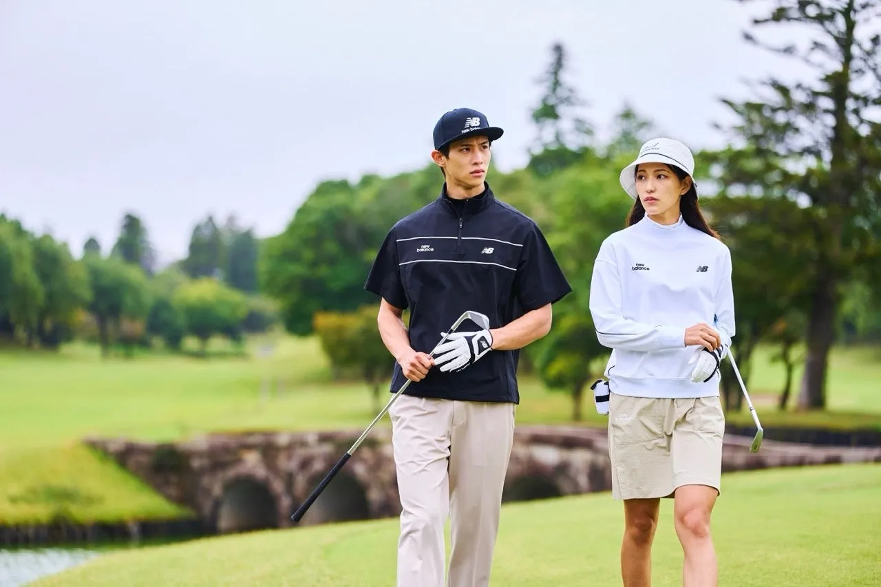 ゴルフウェアを着た男女がゴルフ場を歩いている様子。