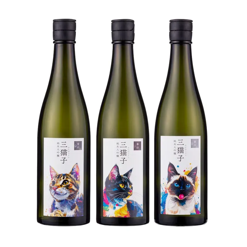 3本の日本酒の瓶。それぞれの瓶には猫の絵が描かれたラベルが付いている。