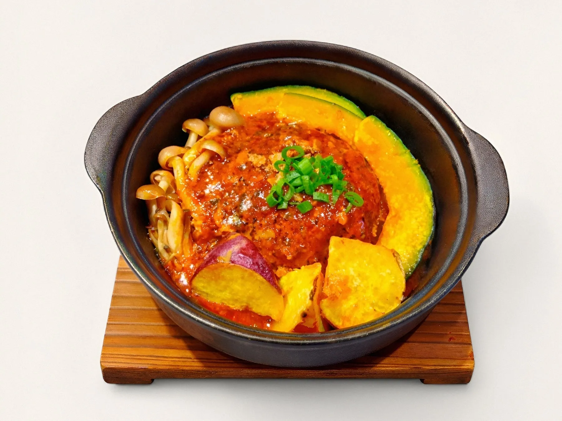 熱々のハンバーグが乗った料理の写真です。カボチャ、さつまいも、きのこも添えられています。