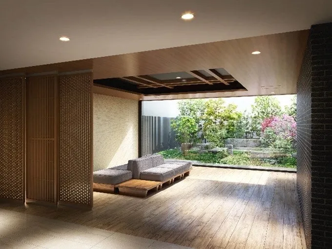 庭に面したリビングルームの様子を描いた画像です。木製の床と天井、格子状の仕切り、グレーのソファと木製のローテーブルが配置されています。窓の外には庭があり、緑豊かな木々や草花が鮮やかに映っています。