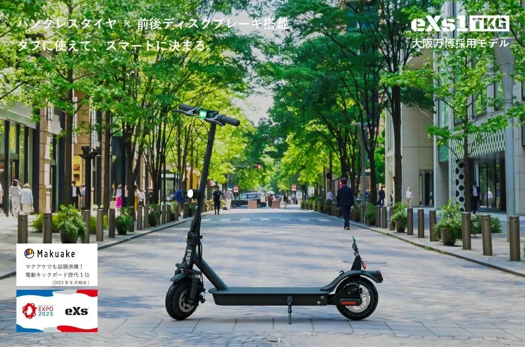 電動キックボードが、街路樹が並ぶ道を走っている様子を写した写真。スタイリッシュなデザインで、大阪万博採用モデルであることや、Makuakeでのランキング1位を獲得したことが示されている。背景には、歩行者や車が行き交う様子が映し出されている。