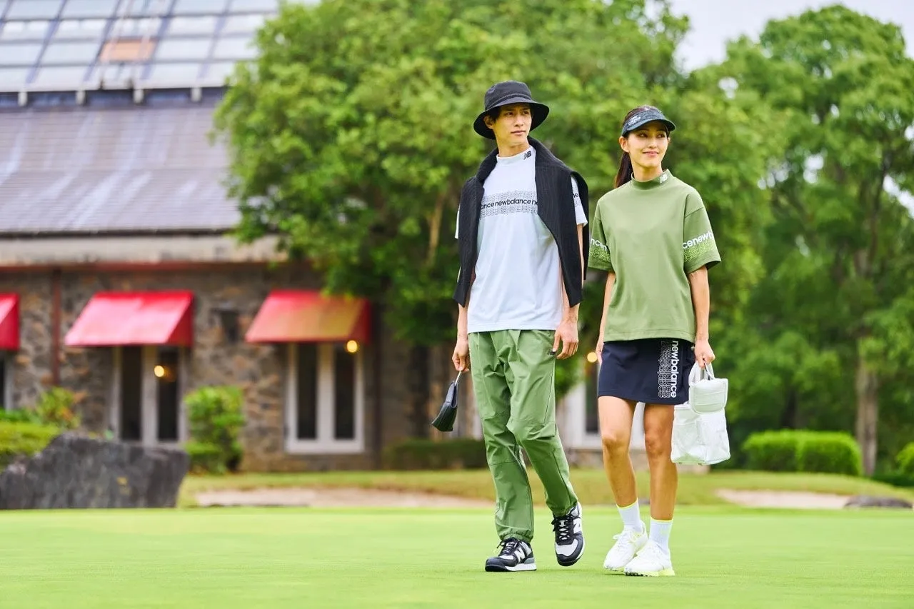 ゴルフウェアを着た男女が、ゴルフ場を歩いている様子。