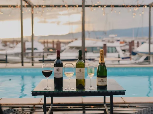 プールサイドのテーブルに並べられたワインボトルやグラス