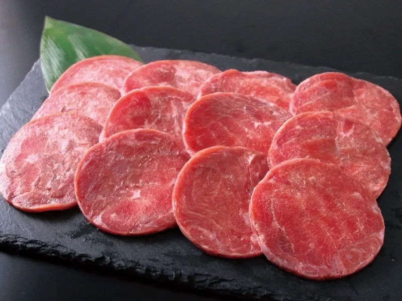 黒いお皿に並べられた、美味しそうな生肉のスライス。